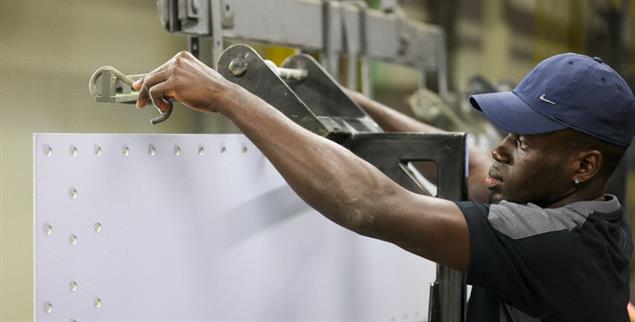 Abdoulle Bojang aus Gambia, Mitarbeiter der omeras GmbH, hängt Stahlbleche für die Oberflächenbehandlung an ein Transportband. In Sachsen gehen mehr Fachkräfte in den Ruhestand als junge Menschen ins Arbeitsleben starten. Deswegen braucht es nach Ansicht von Fachleuten mehr Arbeits- und Fachkräfte aus dem Ausland. Deren Anteil hat sich laut Regionaldirektion der Bundesagentur für Arbeit seit 2013 mehr als vervierfacht von 1,8 auf 7,4 Prozent. Bundesweit liegt der Anteil allerdings etwa doppelt so hoch. Wirtschaftsminister Dulig (SPD) informiert sich am selben Tag in mehreren Unternehmen über ihre Erfahrungen mit internationalen Teams.