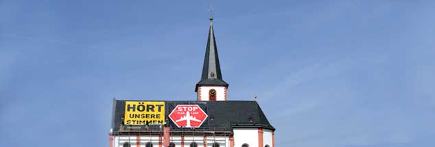 Der Protest gegen den Fluglärm ist in der Rhein-Main-Region immer öfter auch aus der Luft zu sehen: Hier wehrt sich die katholische St. Peter und Paul-Gemeinde Hochheim mit starken Worten auf ihrem Kirchendach. (Foto: pa/Dedert)