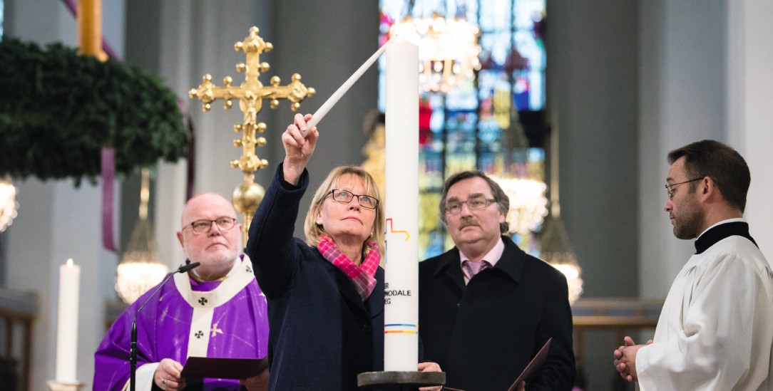 Mal sehen, ob es brennt. Karin Kortmann, Vizepräsidentin des Zentralkomitees der Katholiken in Deutschland zündet im Münchner Dom die Synodalkerze an. Links: Kardinal Marx (Foto: epd/Balk)