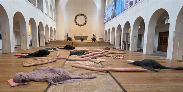Zuflucht für erschöpfte Wesen: »When Animals Fall from the Sky« von Eva Kotátková in der Christ-König-Kirche in Bochum. Die Werke von Małgorzata Mirga-Tas im Hintergrund bewahren die Erinnerung an Roma-Geschichte. (Foto: Anne Strotmann)