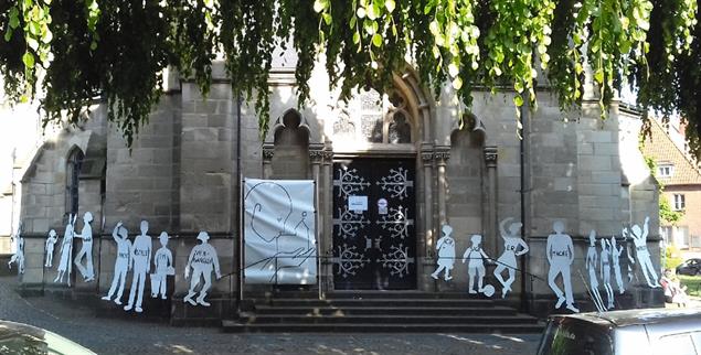 Tanzende Pappfiguren an der Heilig-Kreuz-Kirche in Münster: Das Kunstprojekt von Maria 2.0 entstand an einem Samstag im Mai – und wurde nur Stunden später geschändet (Foto: Kötter)