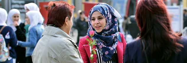 »Wir sind die Neuen«: Die 21-jährige Seba Bashir aus Syrien überreicht einer Erfurterin als Dankeschön für das herzliche Willkommen eine Rose. (Foto: pa/Schutt)
