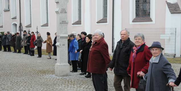 Kirchen-Umarmung in Thalfingen bei Neu-Ulm: Die symbolische Geste hat ihr Vorbild in England, wo dieses Ritual einmal im Jahr Tradition ist. Am zweiten Fastensonntag protestierten jetzt über 150 Gemeinden der Diözese Augsburg mit der Aktion gehen eine umstrittene Strukturreform. (Foto: Groß)