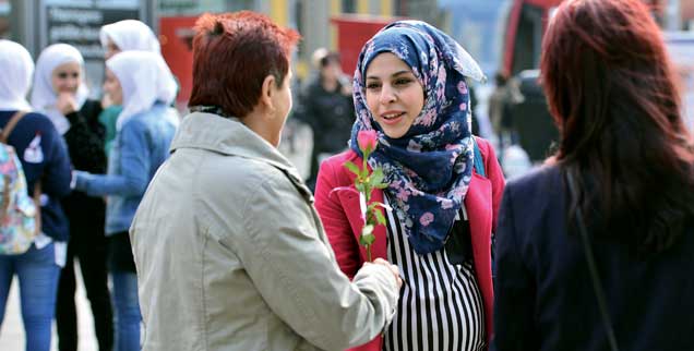 »Wir sind die Neuen«: Die 21-jährige Seba Bashir aus Syrien überreicht einer Erfurterin als Dankeschön für das herzliche Willkommen eine Rose. (Foto: pa/Schutt)
