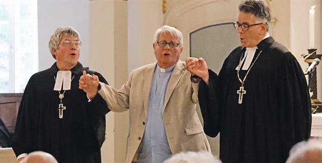 Starkes Zeichen: Jürgen Hauskeller mit den Bischöfen Friedrich Kramer und Tobias Schüfer an den Händen. (Foto: Michael Bauroth)