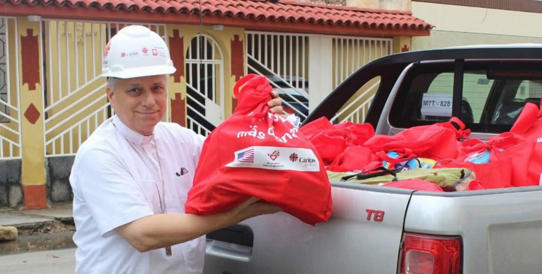 Anpacken nach der Flut: Robert Francis Prevost, Bischof von Chiclayo (Peru), hilft im Februar 2017, Hilfsgüter der Caritas im Überschwemmungsgebiet zu verteilen (Foto: kna)