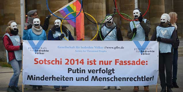 Mitglieder der Gesellschaft für bedrohte Völker protestieren am 04.12.2013 in Kassel am Rande des sog. "Petersburger Dialogs" zwischen Russen und Deutschen gegen die russische Politik. Menschenrechtsverletzungen sind in Russland an der Tagesordnung. Würde ein Boykott der Olympischen Winterspiele in dem Land die Lage bedrohter Menschen verbessern? Das ist Thema unserer Online-Umfrage. (Foto: pa/Zucchi)
 