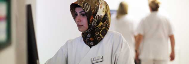 Die medizinisch-technische Assistentin Betül Caliscan trägt bei ihrer Arbeit in einem Lübecker Krankenhaus auf der Radiologie ein Kopftuch (Foto vom 18.10.2011). Während Wirtschaftsverbände angesichts des Fachkräftemangels junge Menschen mit Migrationshintergrund als Arbeitskräfte umwerben, ist das Kopftuch bei muslimischen Frauen oft ein Einstellungshindernis. Eine evangelische Klinik in Bochum weigert sich jedenfalls, eine Mitarbeiterin mit Kopftuch arbeiten zu lassen.Das Bundesarbeitsgericht gab der Klinik vor zwei Tagen im Rechtstreit um diese Frage recht. Die Klägerin arbeitete bislang viele Jahre ohne Kopftuch in jenem evangelischen Krankenhaus; nun wollte sie es gern tragen. Das wurde ihr verboten. (Foto: pa/Nietfeld)