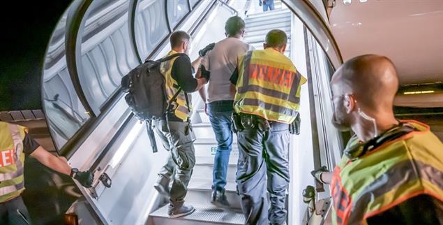 Deportation in große Gefahr: Polizisten bringen Afghanen in ein Flugzeug. (Foto: PA/Michael Kappeler)