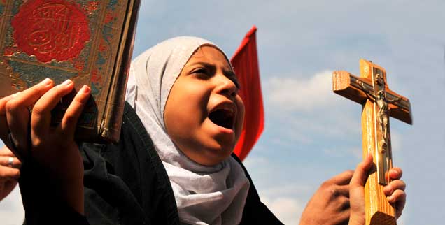 Mit Koran und Kreuz auf der Straße: Eine junge Frau demonstriert in Kairo gemeinsam mit Hunderten von Menschen gegen Konfessionalismus und Feindschaft unter den Religionen. (Foto: pa/upi/Hosam /landov)