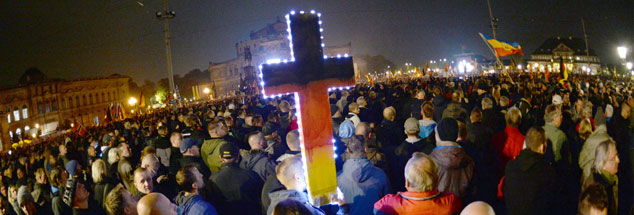 Pegida-Anhänger während einer Demonstration in Dresden: Obwohl sie in Sachsen das Kreuz als Symbol der angeblichen "Religion der Deutschen" vor sich her tragen und viele Demonstranten AfD wählen, zeigen die Wahlergebnisse im benachbarten Sachsen-Anhalt: Unter den zahlreichen AfD-Wählern sind im Vergleich mit westlichen Bundesländern weniger Christen. (Foto: pa/dpa/Ralf Hirschberger)