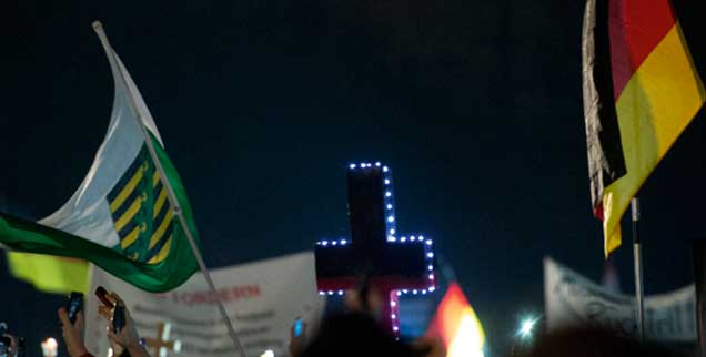 Das Kreuz, ein nationales Symbol? Für rechte Christen ist es das offensichtlich. Wie hier bei einer Demonstration der Pegida-Bewegung. (Foto: pa/Burgi)