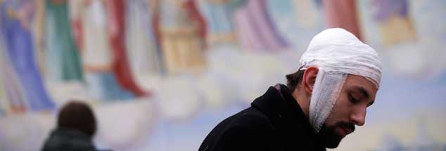 Freiheitskämpfer mit kirchlichem Beistand: Ein verwundeter Demonstrant vor der Michaelskathedrale in Kiew, die während der Proteste als Wärmestube und Lazarett diente. Die Kirchen sind wichtig in der Ukraine. Aber können sie bei der Schlichtung des Konfliktes helfen?  (Foto: Stoyan Nenov/Reuters)

