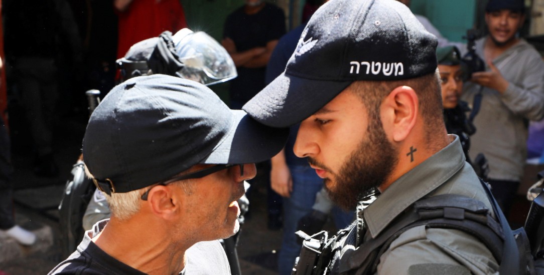 Protest in Jerusalem: Ein Demonstrant und ein israelischer Sicherheitsbeamter stehen sich gegenüber (Foto: REUTERS/Ammar Awad)