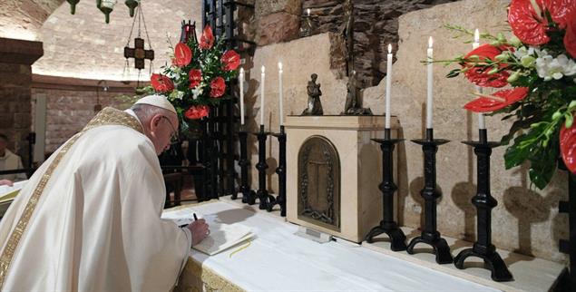 Der Papst unterzeichnet sein Lehrschreiben: Nicht zufällig wählte er dafür Anfang Oktober die Basilika San Francesco in Assisi. Dort liegt das Grab des heiligen Franziskus (Foto: KNA)