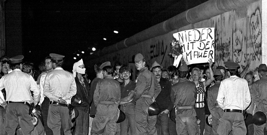 Nieder mit der Mauer: DDR-Grenzsoldaten bei einem Protest gegen die Berliner Mauer am 25. Jahrestag ihrer Errichtung am Checkpoint Charlie im Bezirk Kreuzberg. (Foto: picture alliance/SZ Photo/Hans-Peter Stiebing)