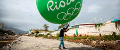 Hier steht heute ein Olympia-Stadion: Ein Arbeiter hält im August 2014 einen grünen Ballon mit der Aufschrift »Rio 2016« hoch. Im August 2016 sieht es an dieser Stelle ganz anders aus. (Foto: pa/dpa/Michael Kappeler)