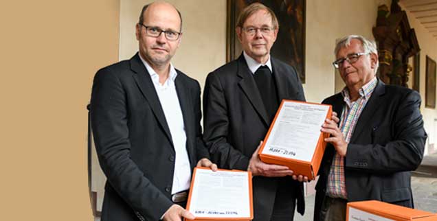 Ein starkes Signal der Gläubigen an den Vatikan: Michael Schrom (links), bei Publik-Forum Ressortleiter Theologie und Kirchen, sowie Redakteur Thomas Seiterich (rechts) übergeben in Fulda genau 22.046 Unterschriften von Unterzeichnern der Papst-Petition »Keine Ausgrenzung am Tisch des Herrn!« an Hans Langendörfer, den Sekretär der Deutschen Bischofskonferenz (Foto: KNA)