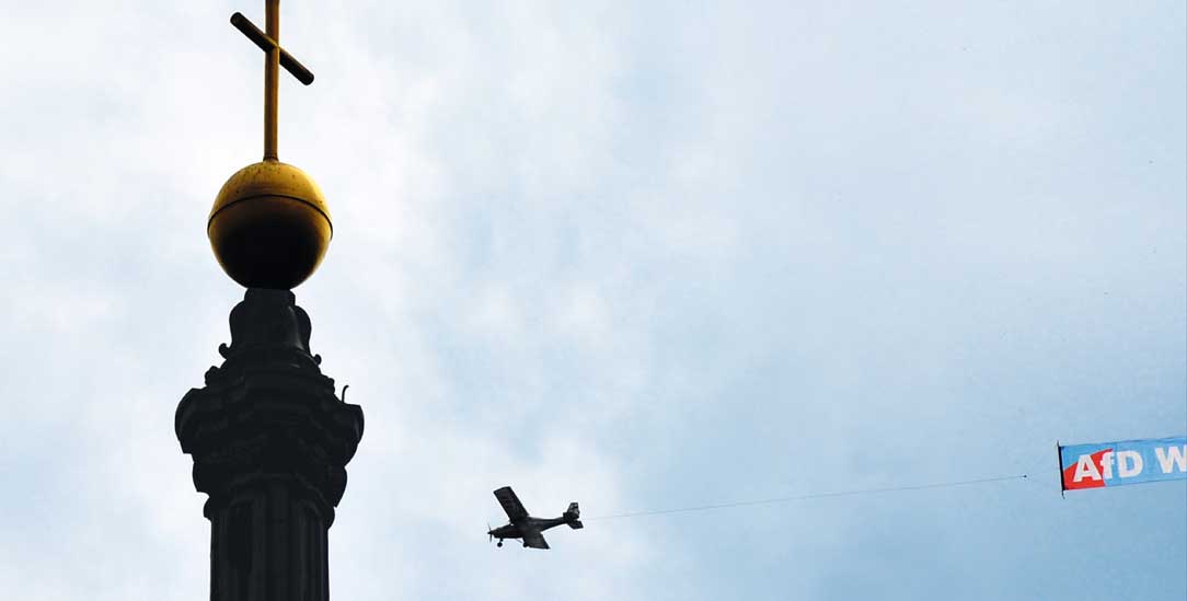 Gefährdung von rechts: Ein Kleinflugzeug mit Wahlwerbung über der Dresdner Hofkirche (Foto: pa/Hiekel)