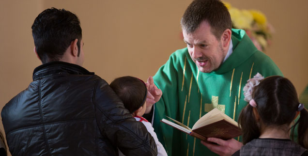 Pastor Gottfried Martens segnet in der Dreieinigkeitskirche in Berlin-Steglitz muslimische Kinder vor ihrer Taufe. Mehrere hundert Iraner und Afghanen sind bei ihm zum Christentum übergetreten. (Foto: pa/dpa/Lukas Schulze)