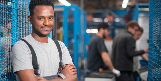 Tedros Gebru an seinem Arbeitsplatz beim Kabelhersteller Lapp in Stuttgart: Nach seiner Flucht aus Eritrea hat er im Betrieb eine Ausbildung abgeschlossen und arbeitet nun in der Kabelherstellung. Künftig könnten Wege nach Deutschland auch über ein Einwanderungsgesetz führen, das die Regierungskoalition entworfen hat. (Foto: pa/Gollnow)
