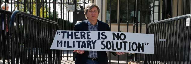 John Dear blokiert einen Eingang zum Weißen Haus in Washington und wird kurze Zeit später festgenommen, wegen ähnlicher Aktionen war er schon in zahlreichen US-amerikanischen Gefängnissen eingesperrt. Mit zivilem Ungehorsam setzt er sich für eine Welt ohne Atomwaffen, ohne Armut  und ohne Gewalt ein (Foto: Downing/Reuters)