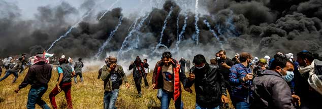 Während Palästinenser Autoreifen anzünden, die die Luft mit Rauch füllen, schießt Israel mitTränengas auf die Demonstranten. Die Proteste spielen sich allesamt auf palästinensischem Territorium im Gazastreifen ab. (Foto: Mohammed Talatene/dpa) 