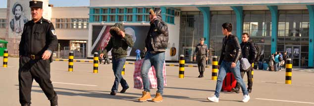 Flughafen Kabul: Ein Gruppe junger Männer verlässt in Begleitung von Polizisten das Flughafengebäude. Einige der in Deutschland abgelehnten Asylbewerber versuchen an diesem Tag Ende Februar 2017 ihr Gesicht zu verbergen. (Foto: pa/Jawad)