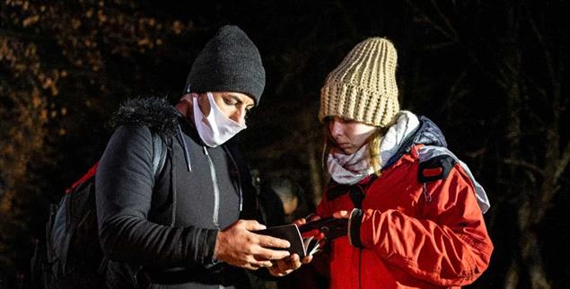 Information und Hilfe: Ein Migrant und eine Freiwillige bei Nacht (Foto: Maciej Moskwa)