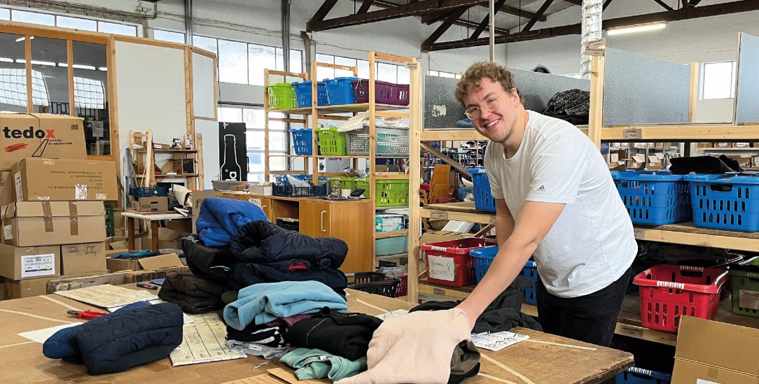 Hosen zu Hosen, Pullis zu Pullis: Daniel May in der Lagerhalle des Vereins Hermine in Würzburg bei der Arbeit. (Foto: Christina Bartholomé)