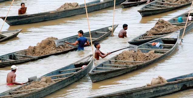 Der Abbau ist in Indien harte Arbeit: Männer stehen bis zum Bauch im Wasser und schaufeln aus dem Kulsi-Fluss Sand in ihre Boote (Foto: pa/epa)