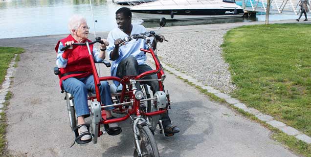 Frische Luft und Eins-zu-eins-Be?treuung: Eine Bewohnerin und ein Mitarbeiter drehen eine Runde im Elektrotandem.  (Foto: Maria-Martha-Stift.de)