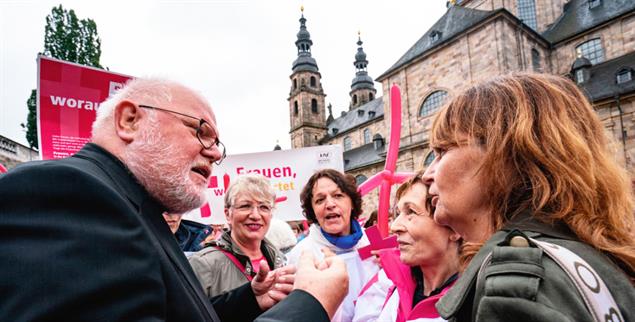 Verstehst Du, was ich meine? Kardinal Marx diskutiert mit einer Demonstrantin vor dem Dom (Foto: pa/Rumpenhorst)