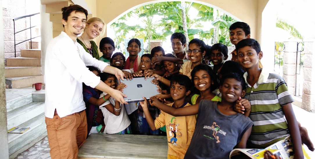 Angekommen: Zwei Reisende übergeben ein Laptop an Kinder in Indien (Foto: www.labdoo.org)