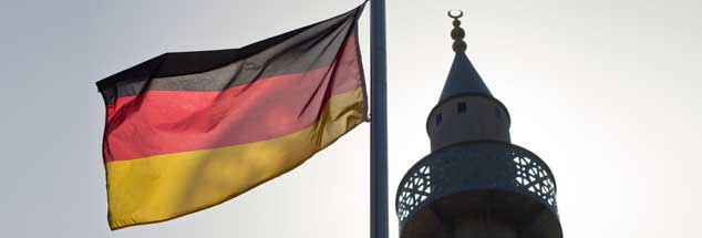 Eine deutsche Fahne weht neben dem Minarett einer Moschee am Rande von Schwäbisch-Hall: Der 3. Oktober erinnert an die deutsche Wiedervereinigung. Es ist auch der Tag der offenen Moschee. (Foto: pa/Rumpenhorst)

