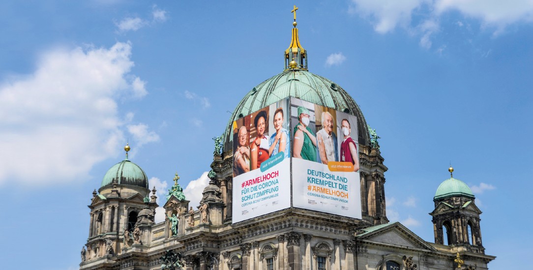 Ärmel hoch: Diese Werbung fürs Impfen am Berliner Dom überzeugt nicht alle (Foto: imago images/Bernd Friedel)