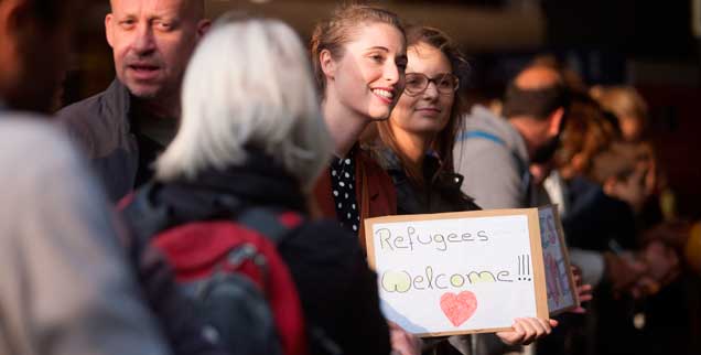 Zahlreiche Menschen in Deutschland haben Flüchtlinge bei ihrer Ankunft, wie hier in München, willikommen geheißen, viele haben sich sogar verpflichtet, eine zeitlang komplett für ihren Unterhalt aufzukommen, doch jetzt sollen sie deutlich länger zahlen, als ihnen Behörden zuvor gesagt hatten (Foto: pa/Peljak)