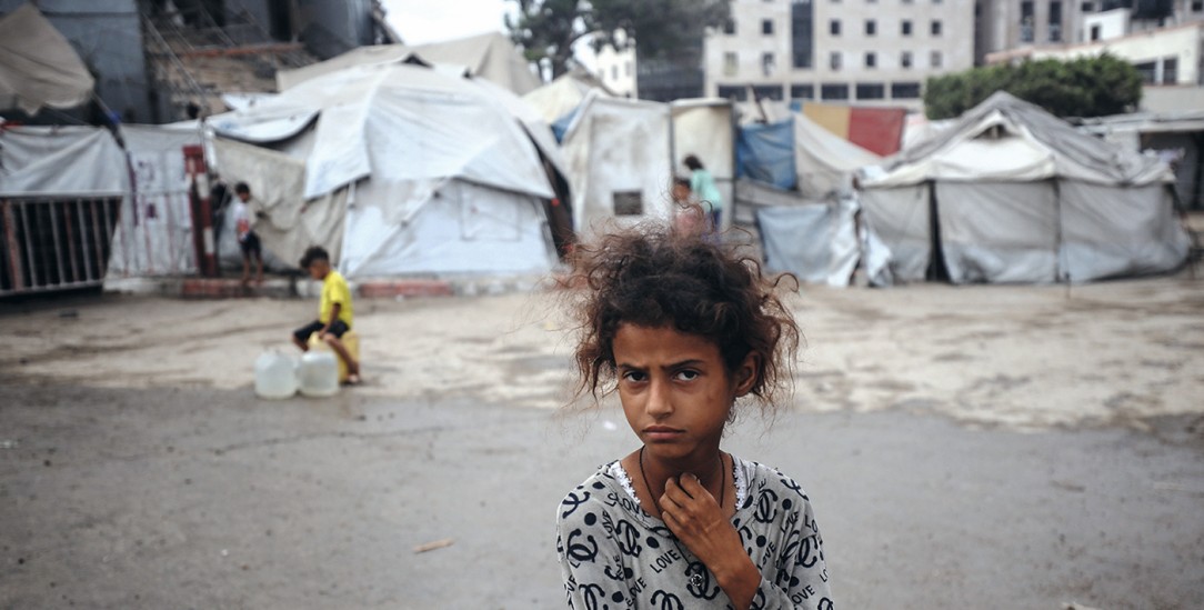 Kindheit in Trümmern: Ein vertriebenes Mädchen vor einem notdürftigen Zeltlager in Gaza-Stadt. (Foto: picture alliance/NurPhoto/Majdi Fathi)