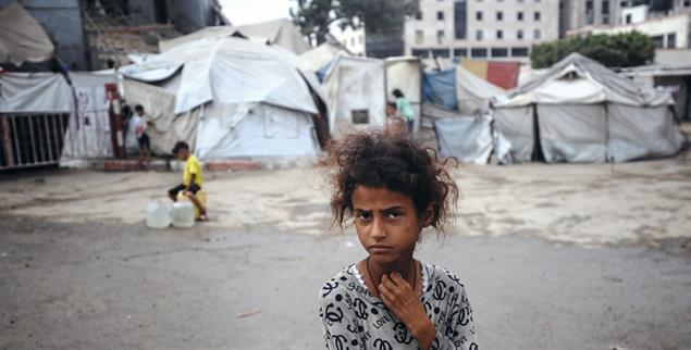 Kindheit in Trümmern: Ein vertriebenes Mädchen vor einem notdürftigen Zeltlager in Gaza-Stadt. (Foto: picture alliance/NurPhoto/Majdi Fathi)