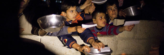 Syrische Flüchtlinge, darunter zahlreiche Kinder, warten auf die Essensausgabe in einem Lager im Grenzgebiet zwischen der Türkei und Syrien: Die Lebensbedingungen in den Camps sind oft schwierig. Nun ist zu erwarten, dass die Versorgung nicht mehr aufrecht erhalten werden kann wie bislang. (Foto: pa/dpa/Maysun)
 