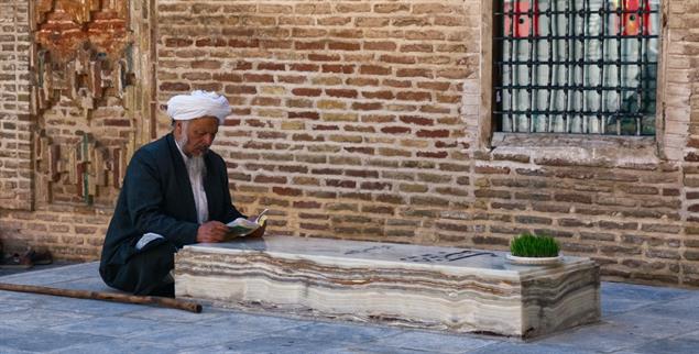 Spirituelle Verbundenheit: An einem Sufi-Grab im nordöstlichen Iran liest ein Besucher aus einem Gebetsbuch. (Foto: Marian Brehmer)