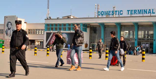Flughafen Kabul: Ein Gruppe junger Männer verlässt in Begleitung von Polizisten das Flughafengebäude. Einige der in Deutschland abgelehnten Asylbewerber versuchen an diesem Tag Ende Februar 2017 ihr Gesicht zu verbergen. (Foto: pa/Jawad)