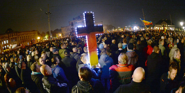 Pegida-Anhänger während einer Demonstration in Dresden: Obwohl sie in Sachsen das Kreuz als Symbol der angeblichen "Religion der Deutschen" vor sich her tragen und viele Demonstranten AfD wählen, zeigen die Wahlergebnisse im benachbarten Sachsen-Anhalt: Unter den zahlreichen AfD-Wählern sind im Vergleich mit westlichen Bundesländern weniger Christen. (Foto: pa/dpa/Ralf Hirschberger)