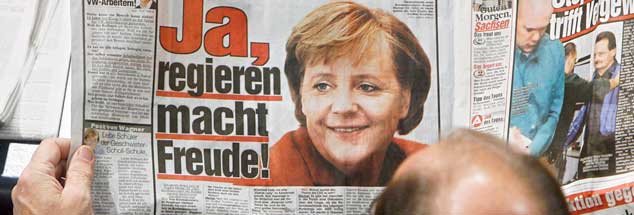 Bild und Merkel sind seit Langem verbunden: Am 22. November 2006 liest ein Abgeordneter schon in der Zeitung, was die Kanzlerin im Bundestag sagen wird (Foto: pa/Kumm)