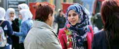 »Wir sind die Neuen«: Die 21-jährige Seba Bashir aus Syrien überreicht einer Erfurterin als Dankeschön für das herzliche Willkommen eine Rose. (Foto: pa/Schutt)
