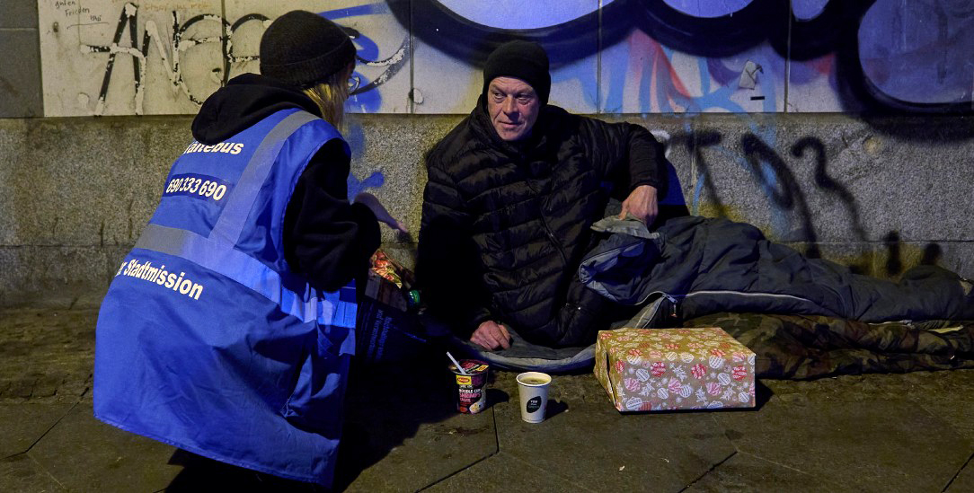 Die Zivilgesellschaft springt ein: Eine Ehrenamtliche der Berliner Stadtmission versorgt einen Obdachlosen am Ostbahnhof. (Foto: PA/epd-Bild/Christian Ditsch)