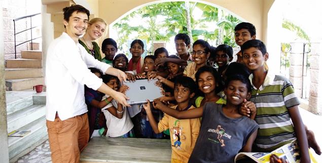 Angekommen: Zwei Reisende übergeben ein Laptop an Kinder in Indien (Foto: www.labdoo.org)