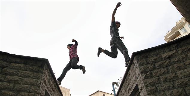 Hindernisse überwinden: Fatemeh Akrami (links im Bild) ist Parkour-Läuferin. Sie rennt, springt und balanciert in Parks und anderswo. Außerdem ist sie die erste Frau, die in Iran Fallschirmspringen ausprobiert – deshalb wird sie auch das Vogelmädchen genannt. Ihr eigenes Geld verdient sie als Gymnastik- und Fitnesstrainerin für Mädchen in Teheran. (Foto: Samaneh Khosravi/Kerber Verlag)